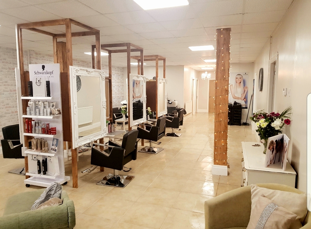 The salon's earlier downstairs space, with white framed mirrors, wooden pillars and comfortable chairs